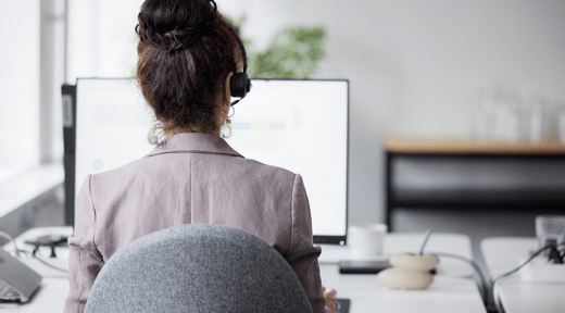 Profesional que presta asistencia a los clientes mediante sistemas de tecnología financiera, mostrando innovación en la gestión del riesgo crediticio.