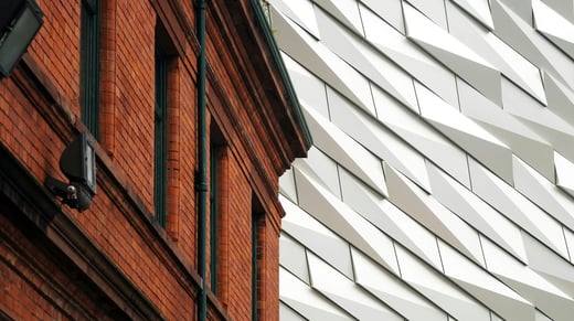 Edificio de ladrillo rojo junto a un moderno edificio de oficinas blanco